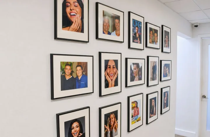 A wall of framed smile portraits in the studio
